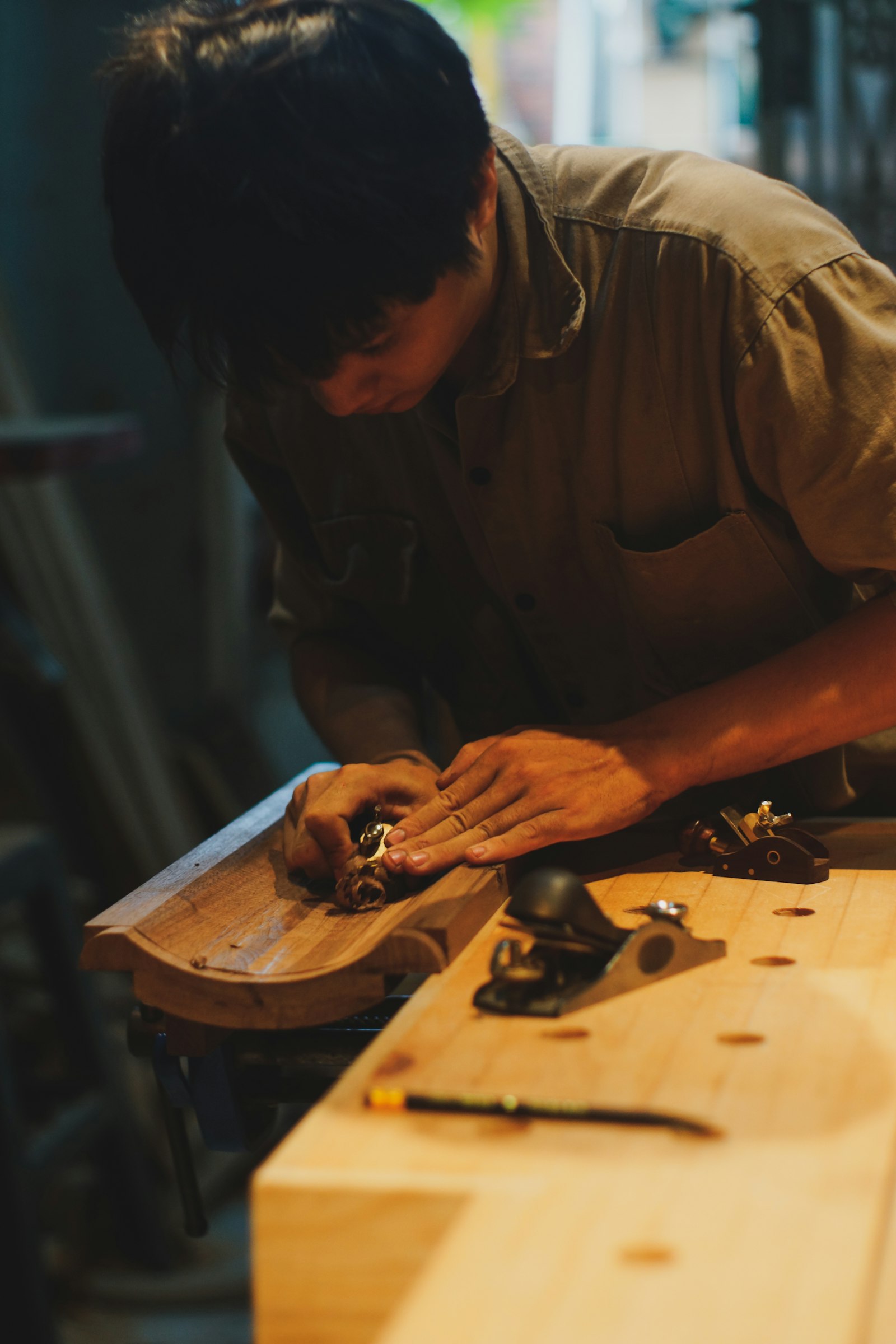 作業場で木材を加工する大工